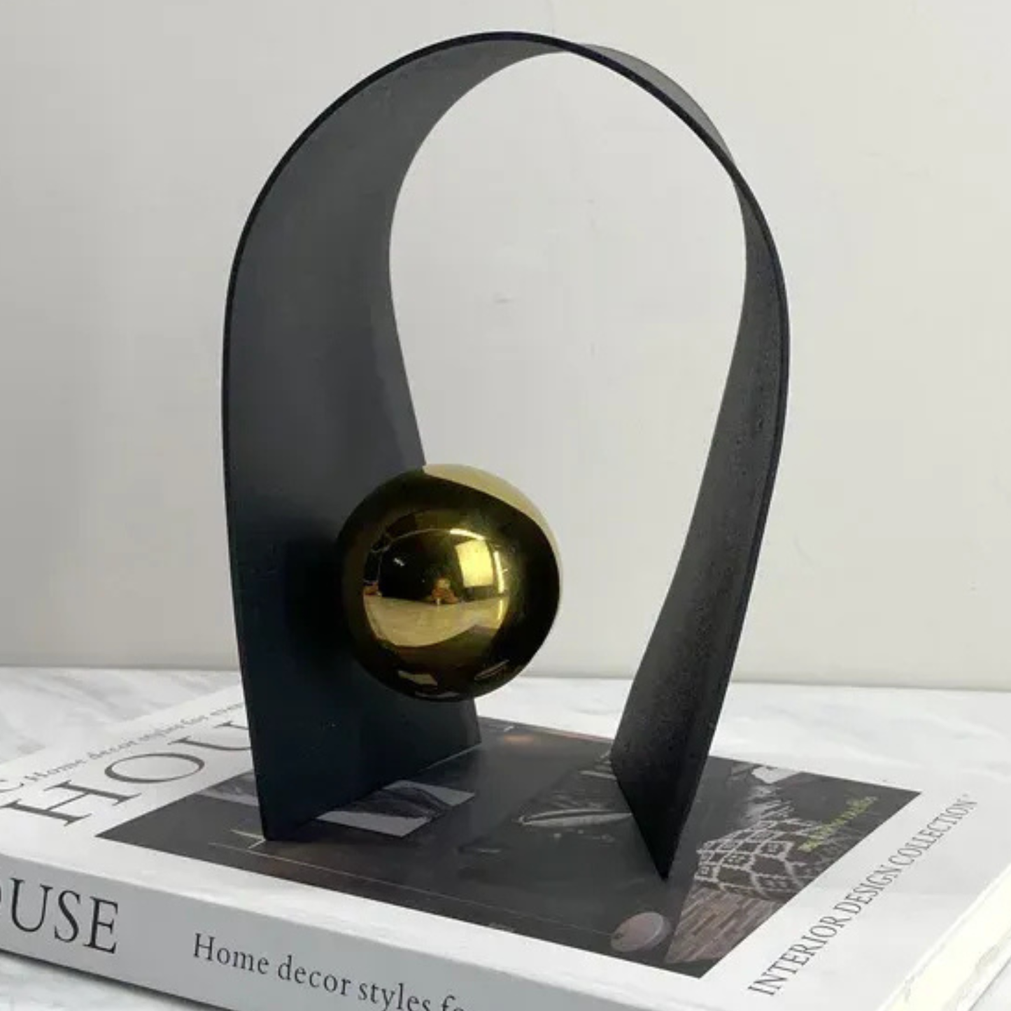 Luxux Schwarze Metallskulptur mit Goldkugel